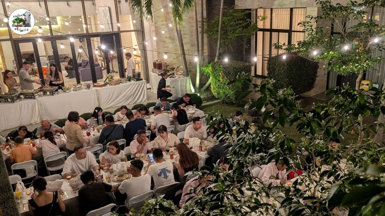 嘉義泰勒瓦莊園戶外婚禮宴會實景,夜色下的燈串與長桌用餐區,賓客自在取餐與交談的溫馨氛圍